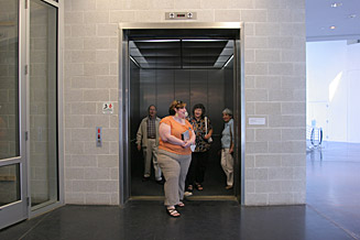 A tour group exits the elevator after listening to Rapture/Rupture